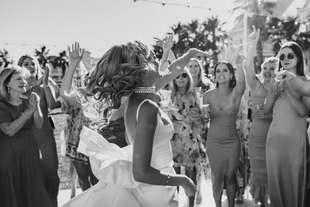 Black and white photo of bride joyfully dancing with her friends and bridesmaids around her. Photo taken by Lillian Jean Photography a Washington based wedding and elopement photographer who specializes in lifestyle wedding photography. 